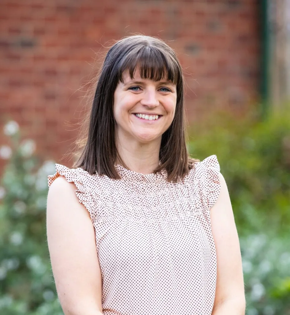 Nutrition Health & Wellbeing dietitian, with shoulder-length hair and a lace top