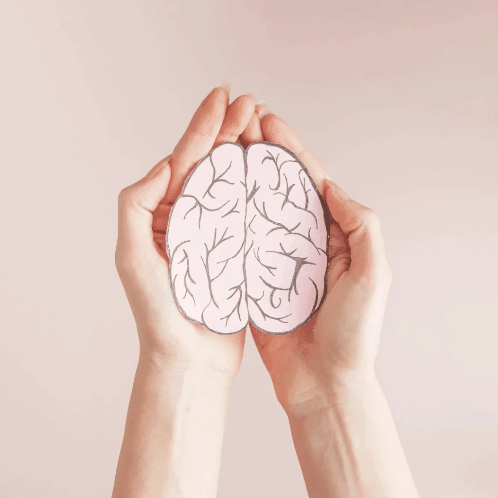 Hands holding a paper model of a brain, representing mental health and nutrition