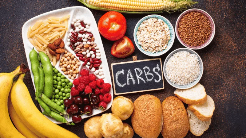 Carbohydrate foods including grains, legumes and vegetables around a Carbs sign